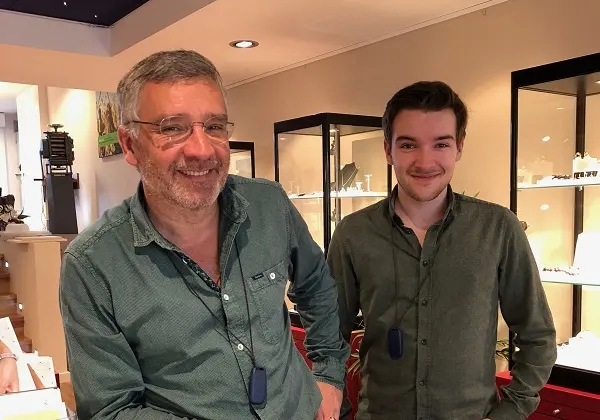 Guus Uilenbroek (links) lachend in de winkel